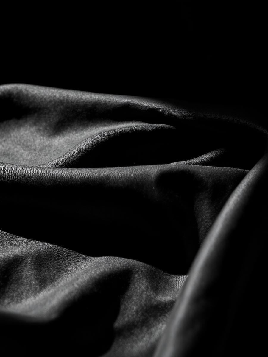 Dark draped fabric under dramatic light
